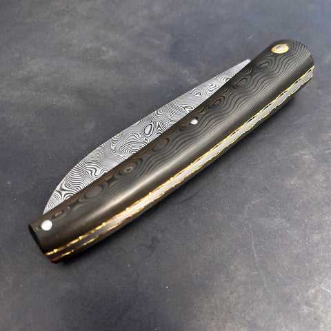 Liadou Exception in carbon fiber/brass, chiseled brass plates & stainless steel Damascus blade