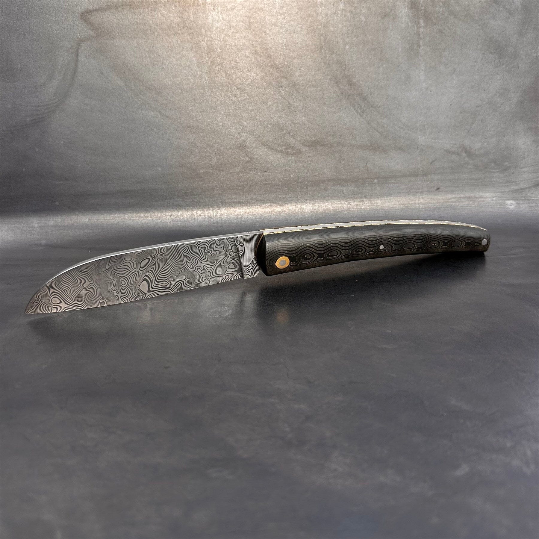 Liadou Exception in carbon fiber/brass, chiselled brass plates &amp; stainless steel Damascus blade